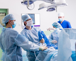 Arthroscope surgery. Orthopedic surgeons in teamwork in the operating room with modern arthroscopic...