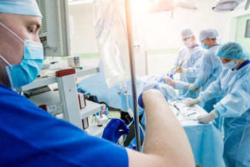 Arthroscope surgery. Orthopedic surgeons in teamwork in the operating room with modern arthroscopic...
