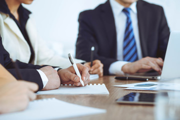 Group of business people or lawyers  work together at meeting in office, hands using tablet and making notes close-up. Negotiation and communication concept