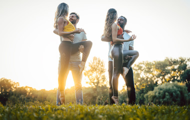 Two couples dancing kizomba during sunset in a park
