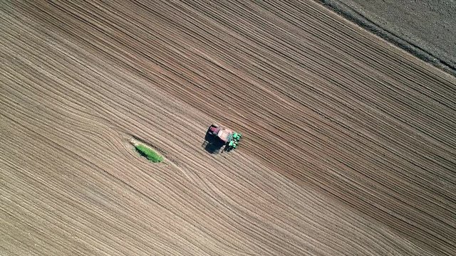 Aerial 4K - Semina con trattore in campo arato