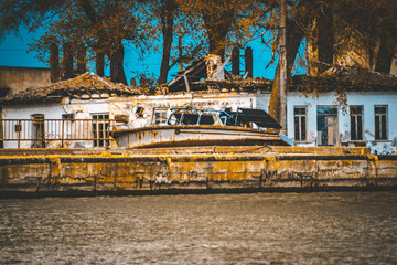 Fototapeta na wymiar Rusty Boat Abandoned on water shore in Danube Delta Abandoned spaces melancholia concept 