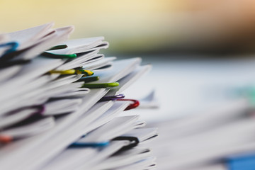 Close up pile of unfinished paperwork on office desk waiting to be managed and inspected. Stack of...