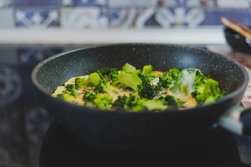 cooking broccoli with eggs in a frying pan