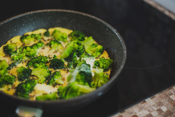 cooking broccoli with eggs in a frying pan