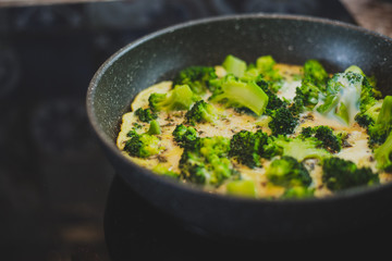 cooking broccoli with eggs in a frying pan