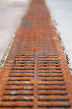 Rusted storm drain tile, close up. Shallow depth of field.