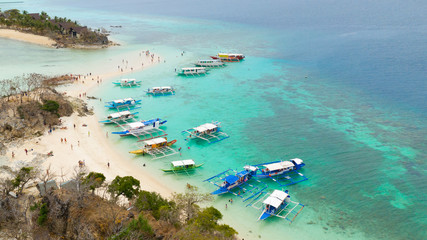 Obraz na płótnie Canvas People relax on island.Many tourist boats on coast of tropical island.