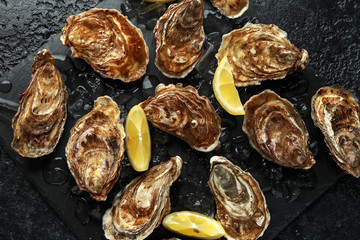 Fresh Oysters platter with lemon and ice. ready to open and eat