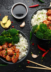 Teriyaki chicken, steamed broccoli and basmati rice served in two Asian clay bowls