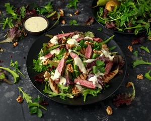 Grilled Beef Steak salad with pears, walnuts and greens vegetables and blue cheese sauce. healthy food.