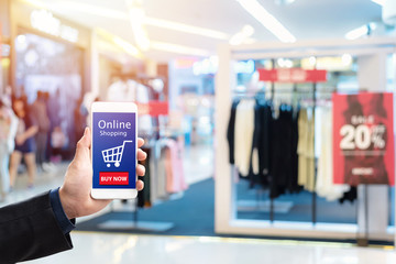 Hand holding mobile phone on shopping center blur in background,Online-shopping- concept.