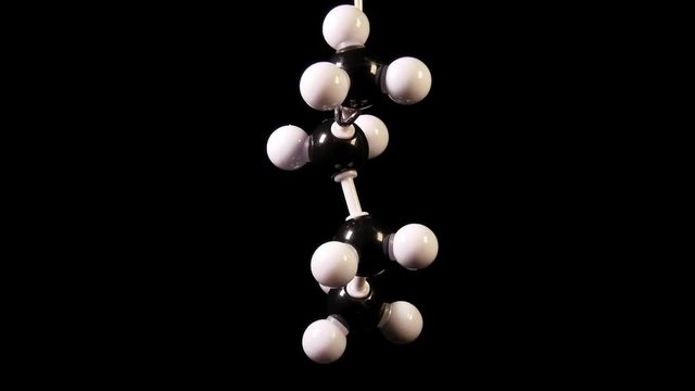 Butane C4H10 molecule rotating on black background