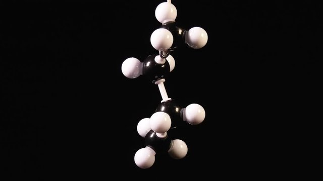 Butane C4H10 molecule rotating on black background