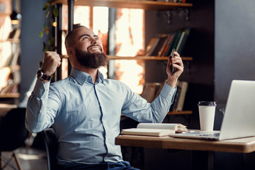 Fototapeta premium Euphoric happy businessman scream read good online news celebrating business success, great result watching game on laptop, excited by victory, betting win, professional achievement, feeling winner