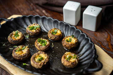 Traditional Italian Mushroom Caps stuffed with Feta as close-up in a rustic frying pan