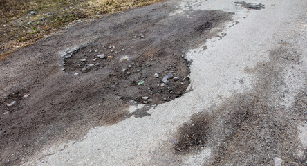 Cracks and pit on the asphalt road as background