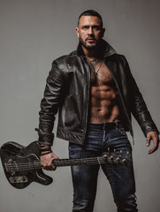 Rock this party. Muscular athletic sexy male with guitar. Confident and handsome brutal man play...