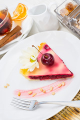 A piece of cake on a served table with tea
