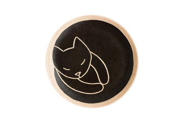 ceramic round plate with a sleeping black cat. clay. isolated on white