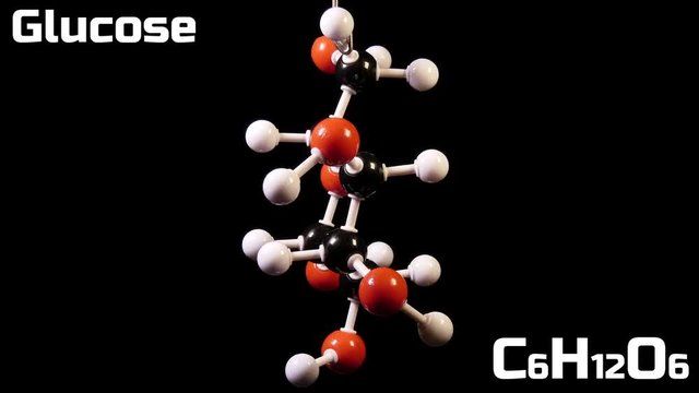 Glucose C6H12O6 molecule rotating on black background