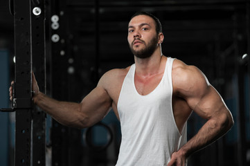 Obraz na płótnie Canvas Sporty Athlete Posing on Background of Gym