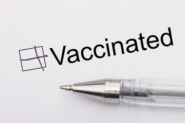 Vaccinated - checkbox with a cross on white paper with pen. Checklist concept.