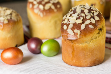 Sweet easter cake (kulich) topped with almond flakes with colored eggs