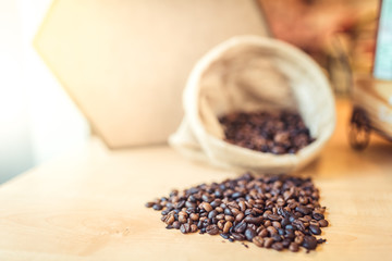 Coffee beans in canvas sack on wooden table