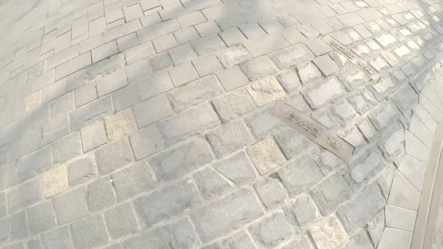 Chinese road marker indicates direction and distance. Several destinations are etched into the ground, written in Chinese characters to show heading and km away of destinations.