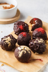 Healthy raw energy balls with cocoa, dates, maca, chia on white background.