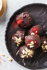 Healthy raw energy balls with cocoa, dates, maca, chia on white background, top view.