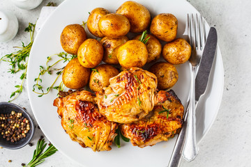 Grilled chicken and baked potatoes in a cast iron skillet.