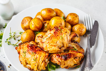 Grilled chicken and baked potatoes in a cast iron skillet.