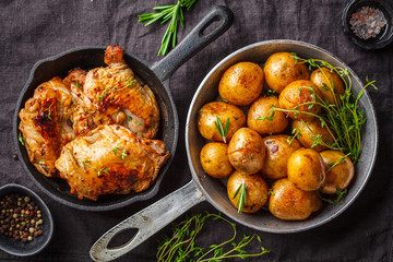 Grilled chicken and baked potatoes in a cast iron skillet.