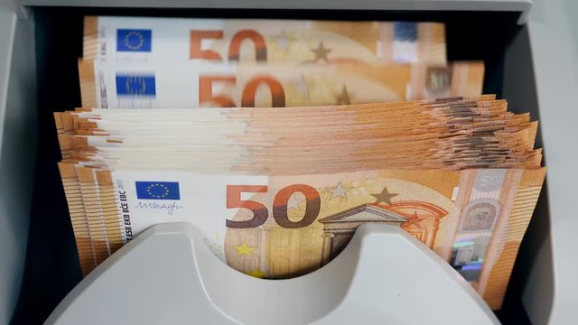 Stacked euro banknotes are getting calculated