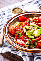 Pasta with herbs and vegetables on wooden background