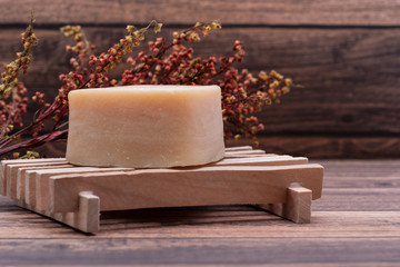 Wooden Soap Holder with a Heart shaped Goat milk Soap on wooden background.