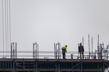 Bauarbeiter hoch oben auf einer Baustelle bereiten die Konstruktion vor