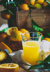 Table with box of fresh orange with orange tree branch and fresh orange juice
