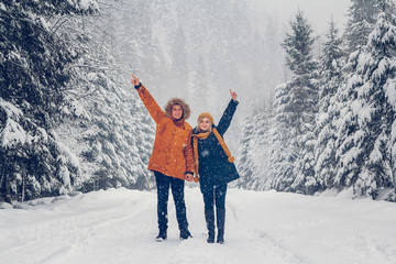 Guy and girl walk and have fun in the forest in winter