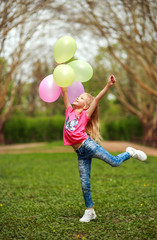 Fototapeta na wymiar Happy girl with balloons jumping in city park celebrating summer lifestyle freshness of nature