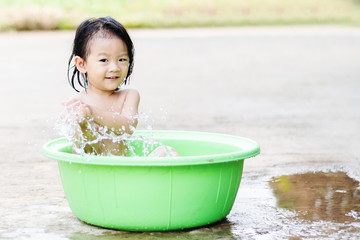 little children sit in basin and had fun playing water