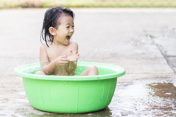 little children sit in basin and had fun playing water