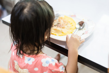 Asian little baby child eating and enjoy breakfast by herself