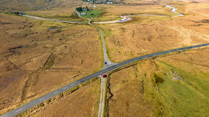 vue aérienne sur un croisement de route au milieu des terres jaunies du Connemara