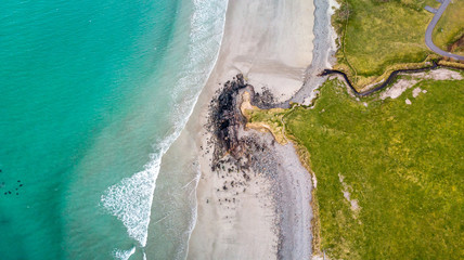 vue aérienne sur une plage et ses rochers avec une mer turquoise