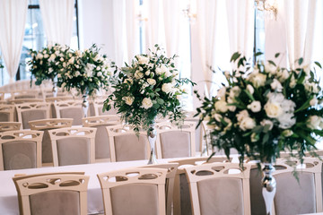 wedding decor, accessories, orchids, roses, eucalyptus, a bouquet in a restaurant, chairs table setting