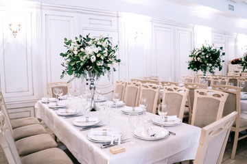 wedding decor, accessories, orchids, roses, eucalyptus, a bouquet in a restaurant, chairs table setting