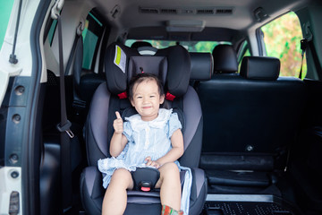 Portrait of cute little baby child sitting in car seat. Child transportation safety